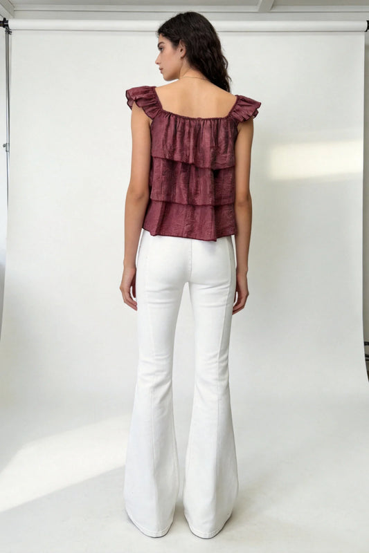 Detalle de volantes en blusa burdeos de tejido texturizado