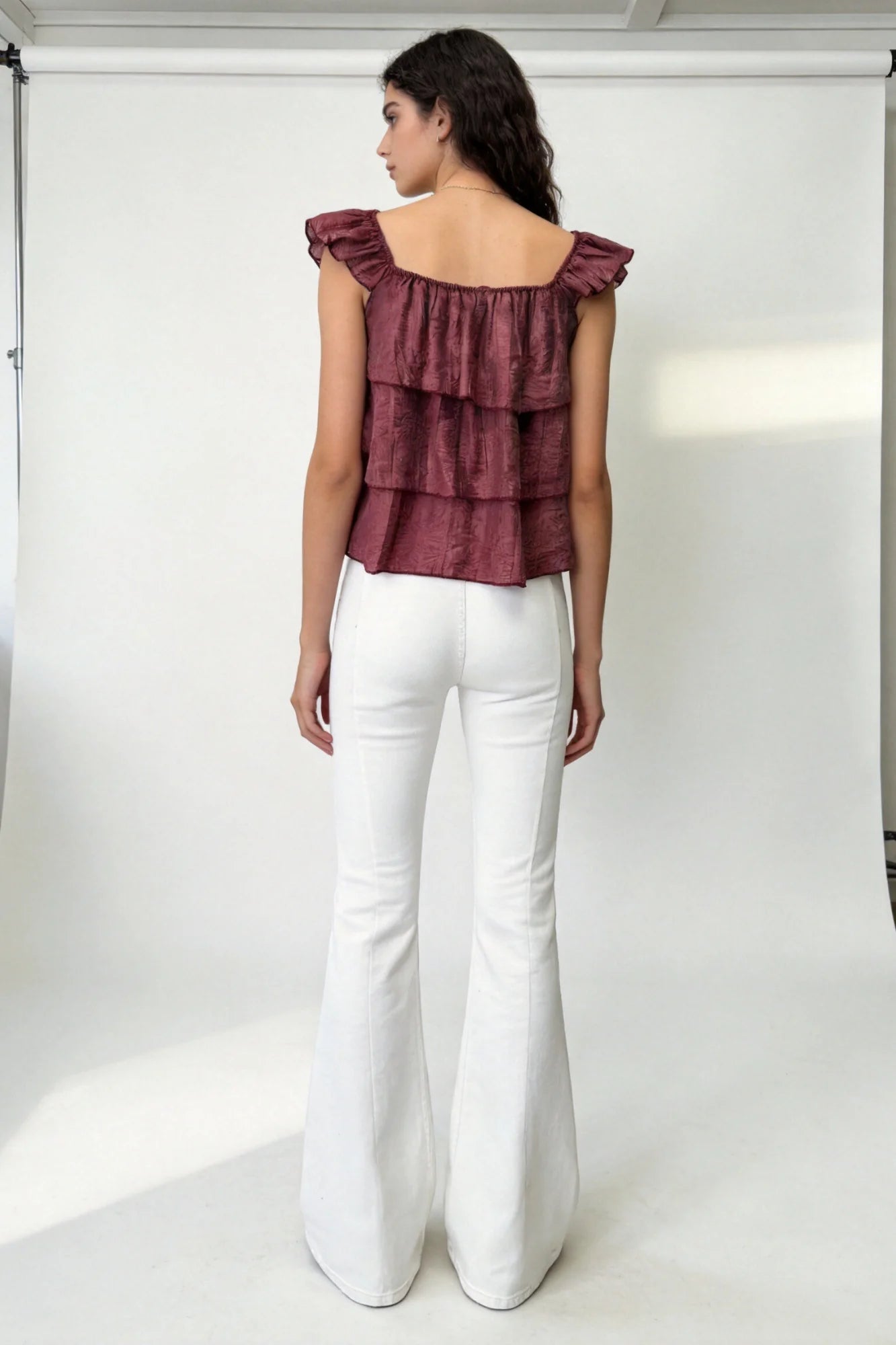 Detalle de volantes en blusa burdeos de tejido texturizado